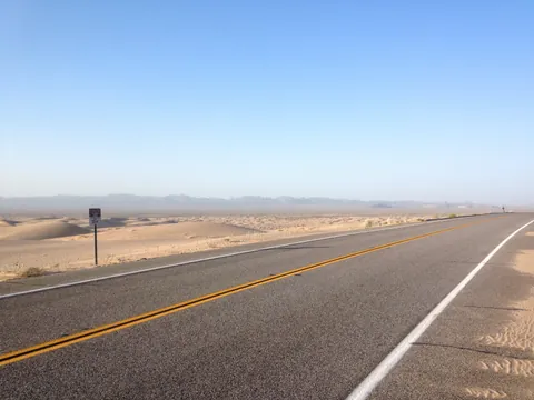 Desert highway through sand dunes