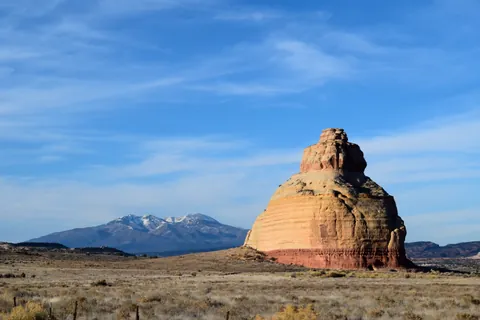 Sandstone butte with La Sal Mountains